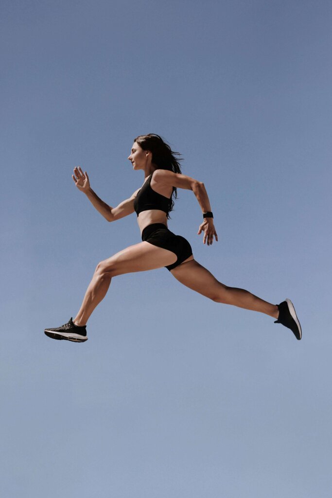 liberdade e energia: mulher saltando com tênis de corrida