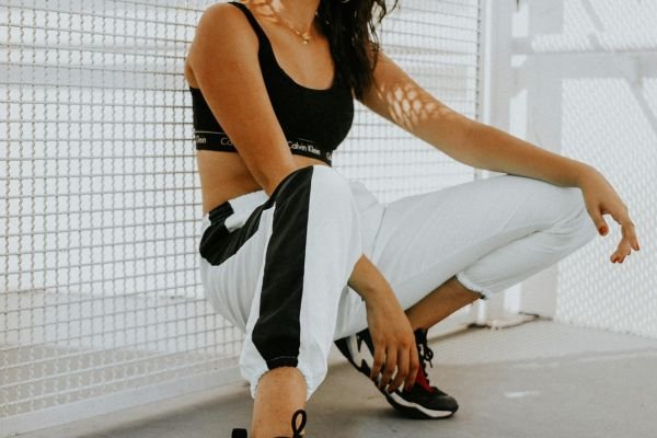 Card com imagem de mulher em roupas esportiva, representando a categoria estilo fitness do tema em foco.